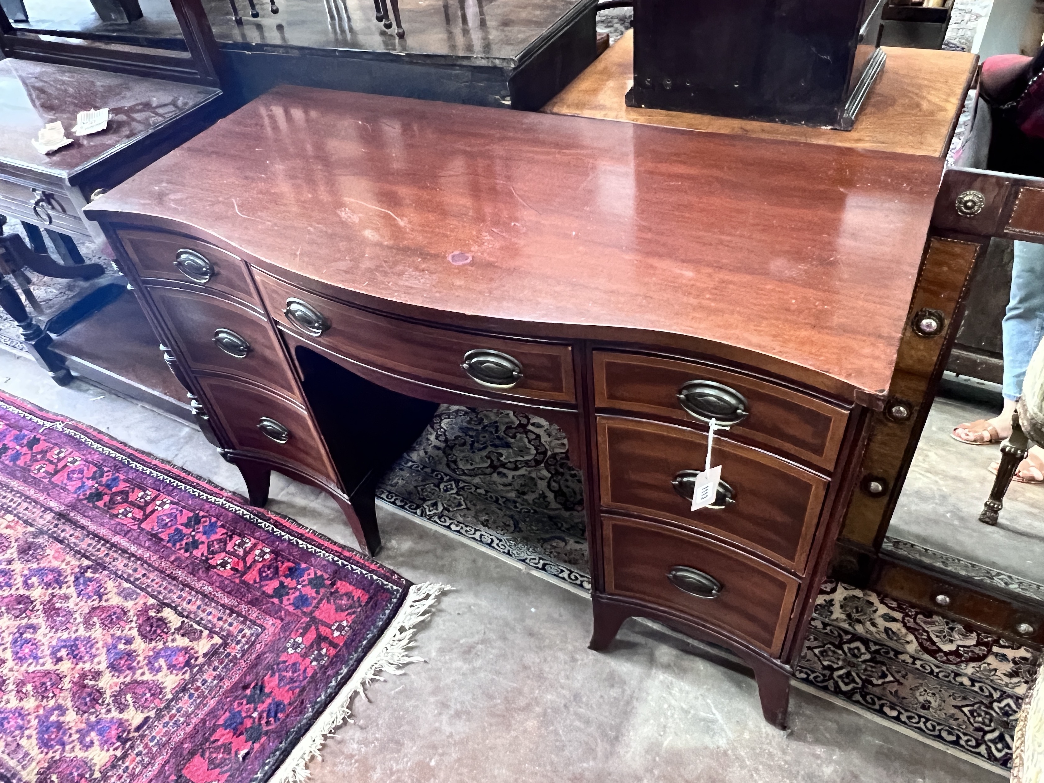 A reproduction 'Drexel Furniture' serpentine mahogany kneehole dressing table, width 117cm, width 51cm, height 77cm